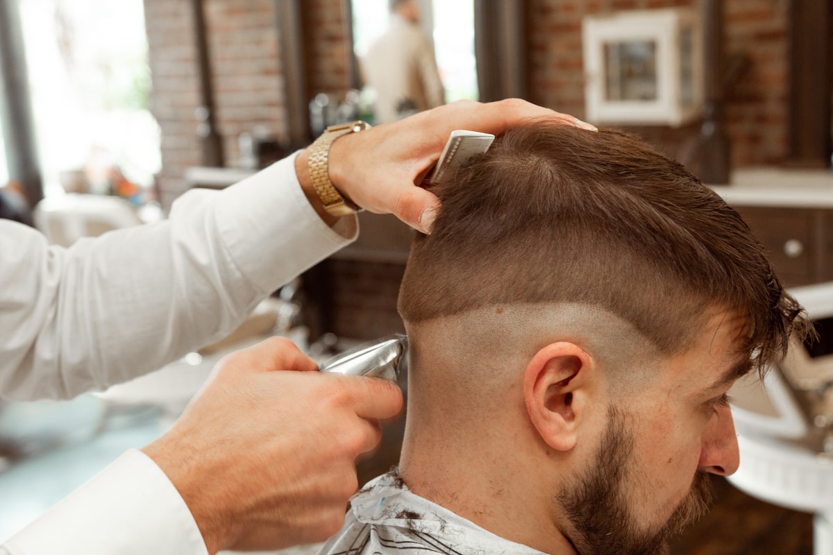 Le barbier réalisant un dégradé à la tondeuse