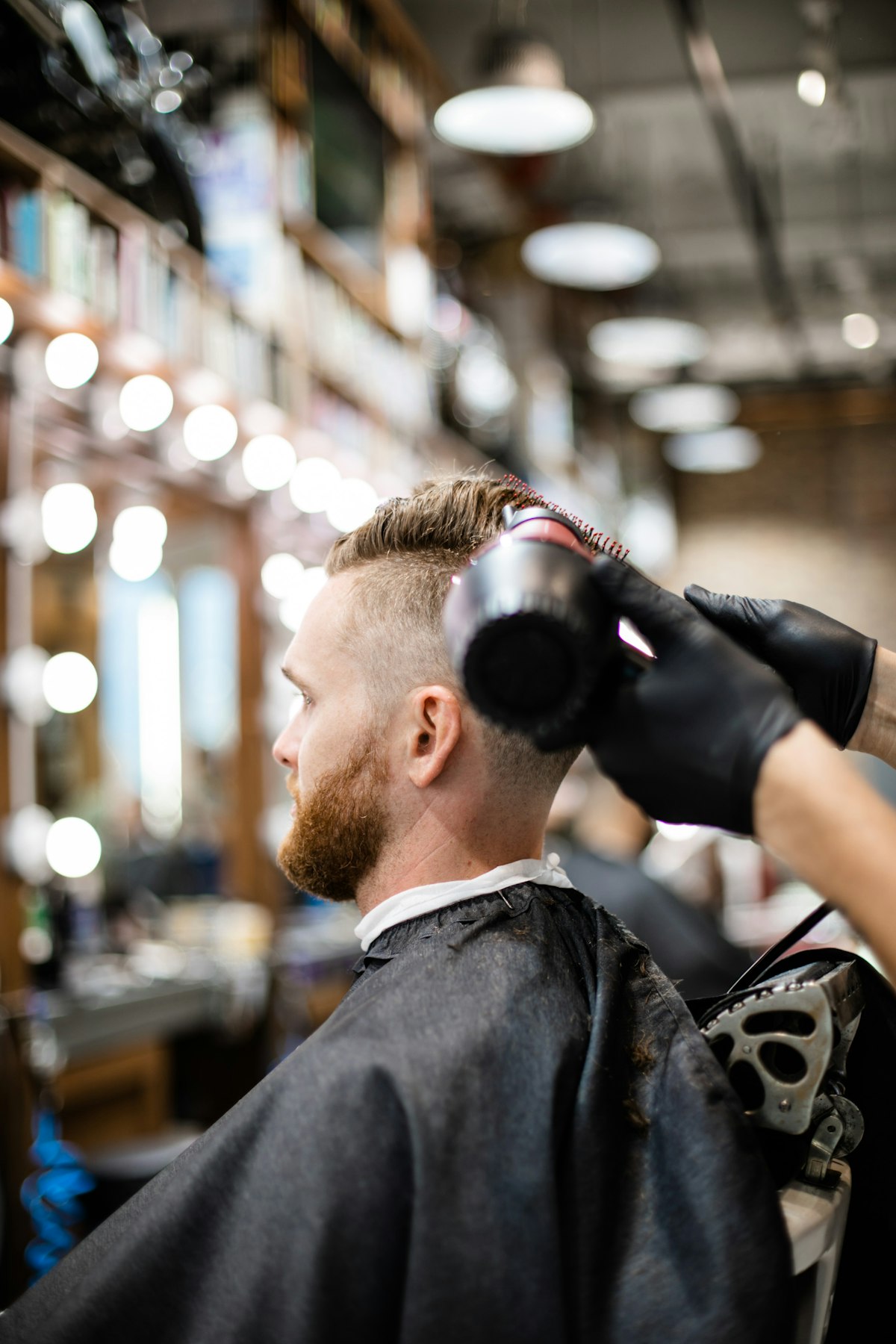 Barbier coiffant un client dans son salon en Bretagne