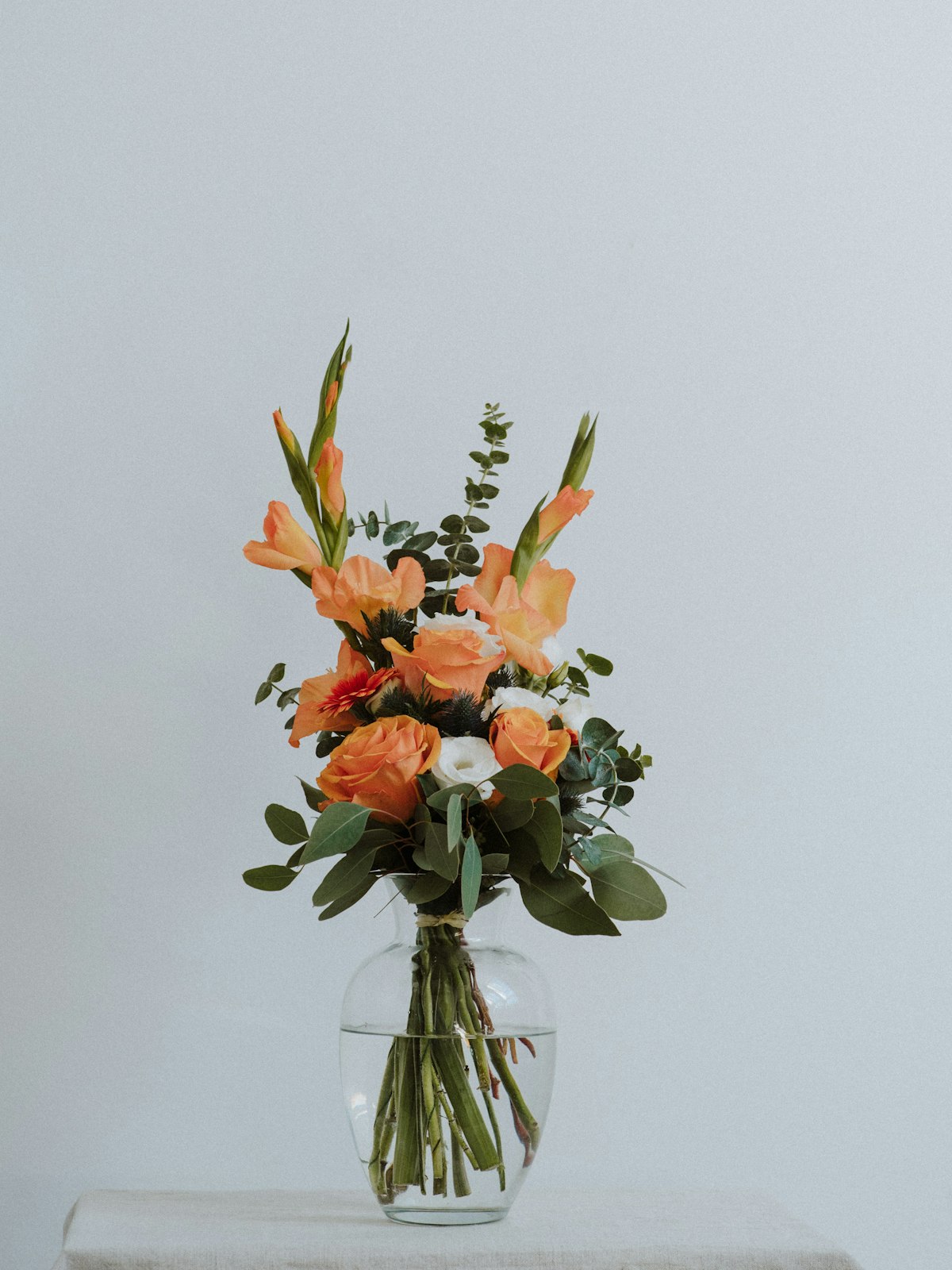 Fleurs oranges et corail de saison en atelier